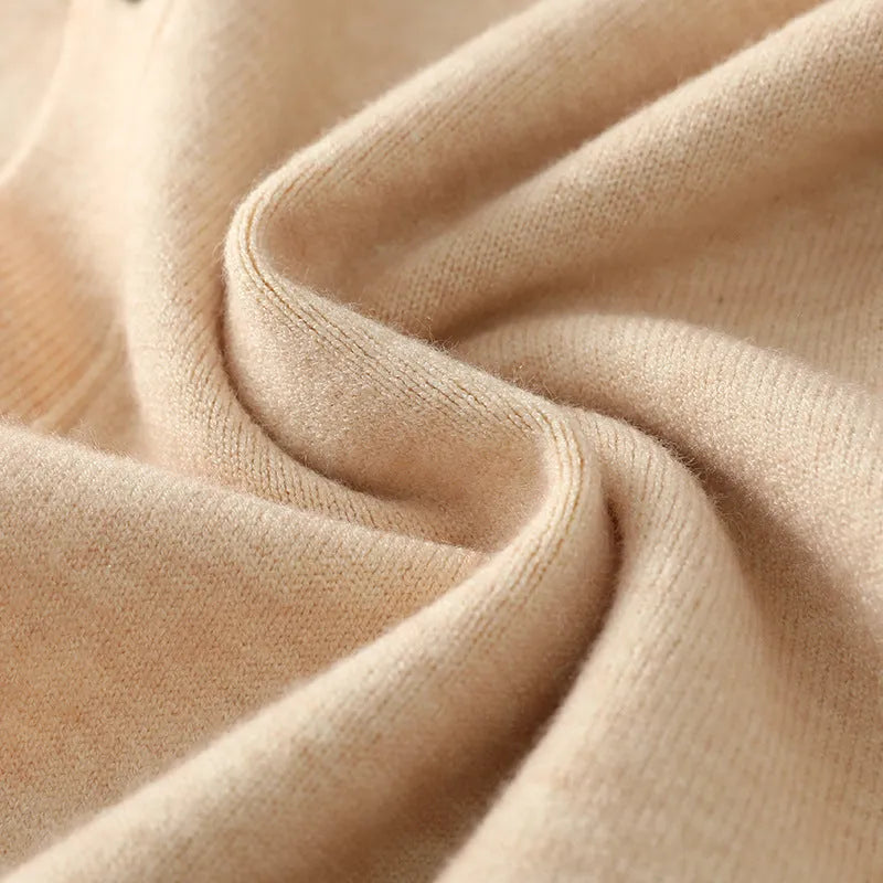 Man wearing a beige V-neck Andy velvet knitted cardigan coat with long sleeves and a loose fit.