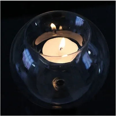Handmade clear round hollow glass candle holder in three size options on wooden table