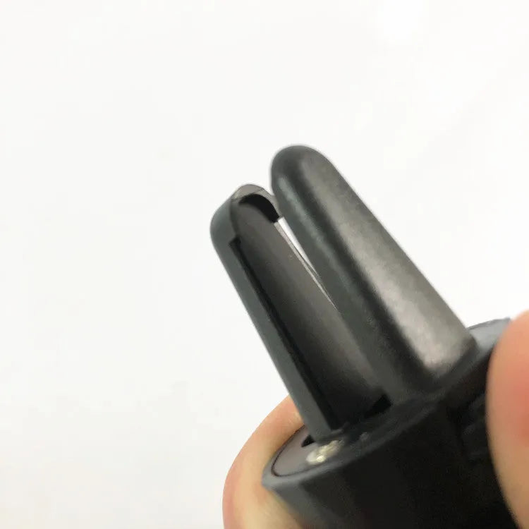 Black universal car phone holder attached to a car air vent.