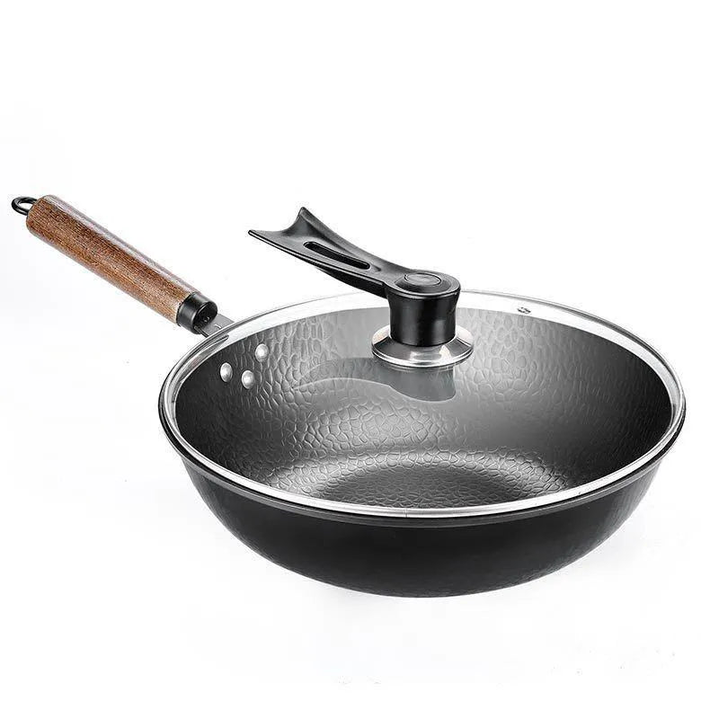 Black traditional iron wok pan with wooden handle and induction base