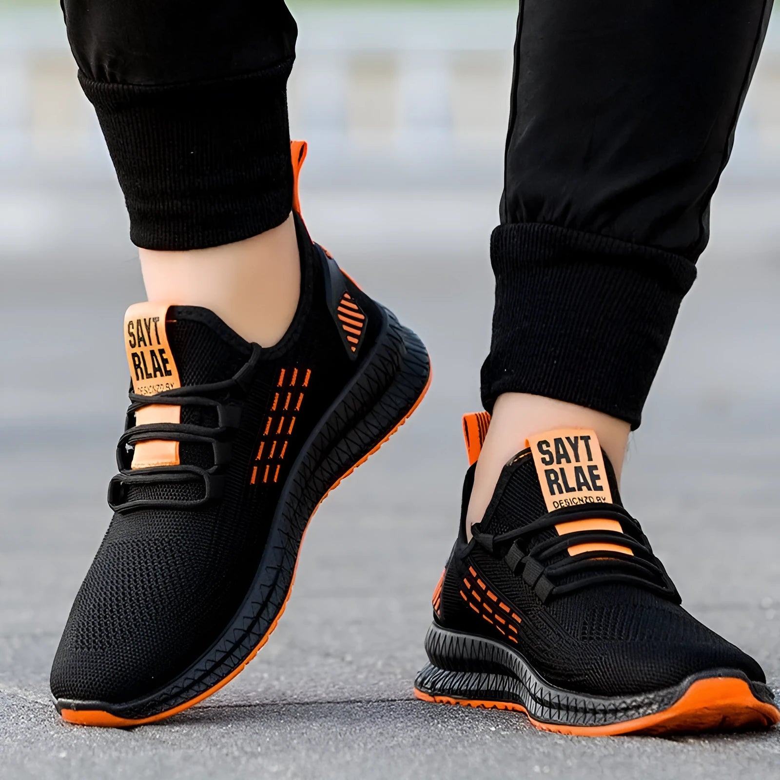 Men's black casual sports shoes with white stripes and a cross-strap detail over a Flying Weave upper.