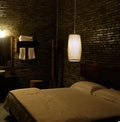 Natural bamboo plait cylindrical wall lamp with woven texture, shown mounted.