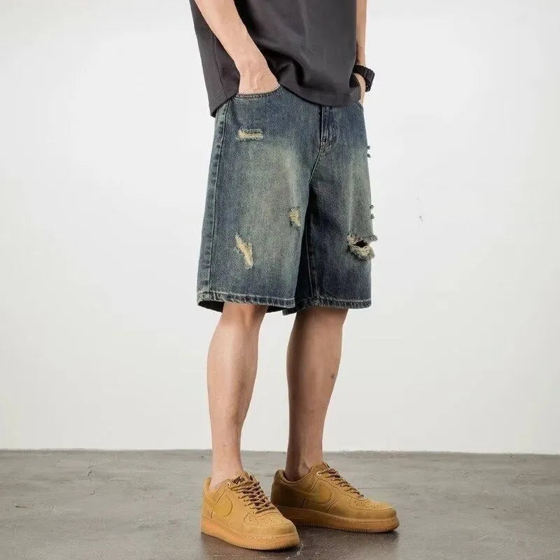 Men's blue distressed denim shorts with a straight leg and retro hole detailing.