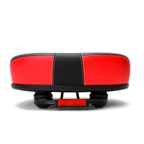 Large red bicycle saddle with reflective stickers, showing thickened design and shock absorber.