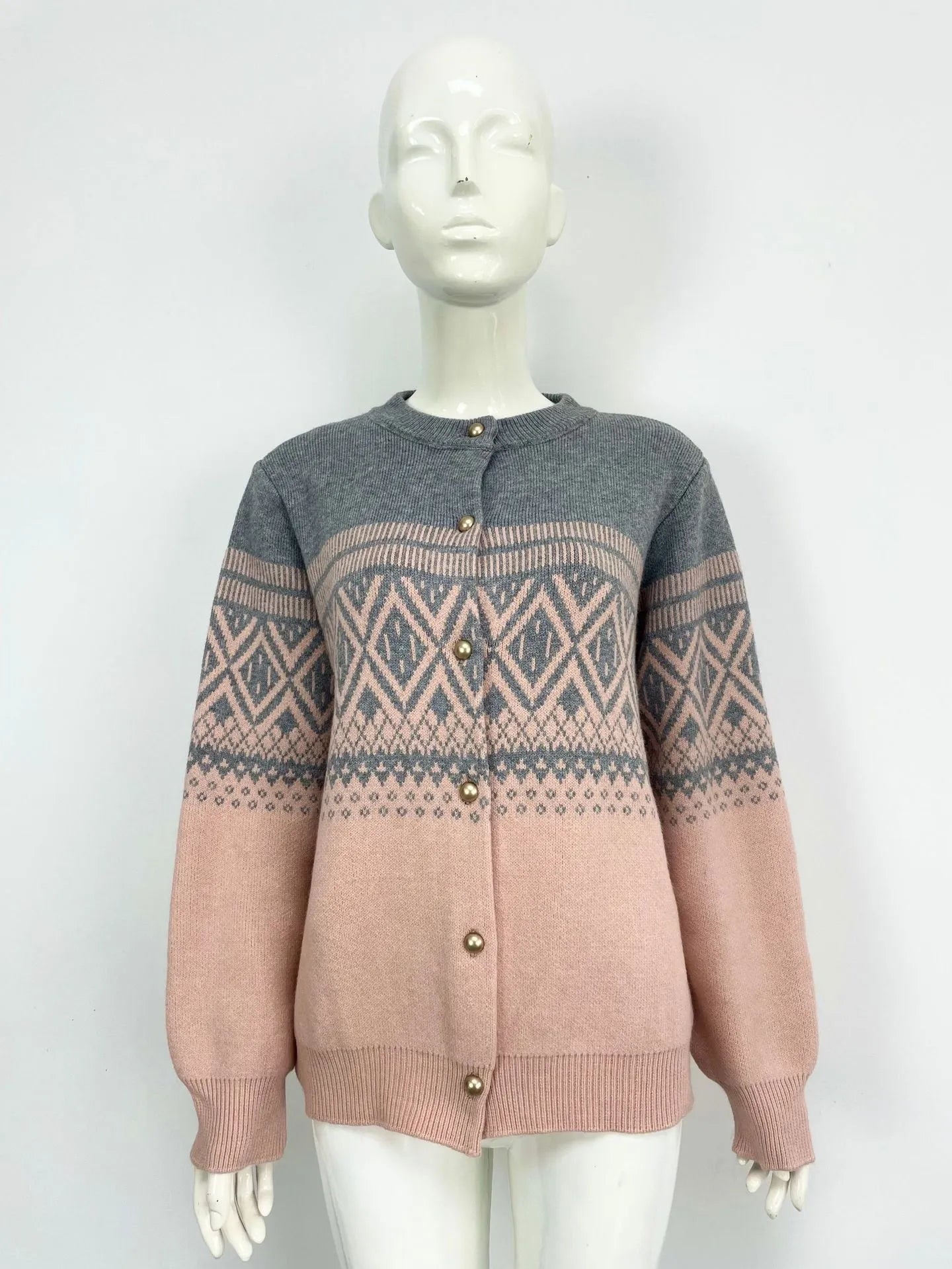 Woman wearing a grey alpaca wool cardigan with a long sleeve diamond pattern in a contrast colour.