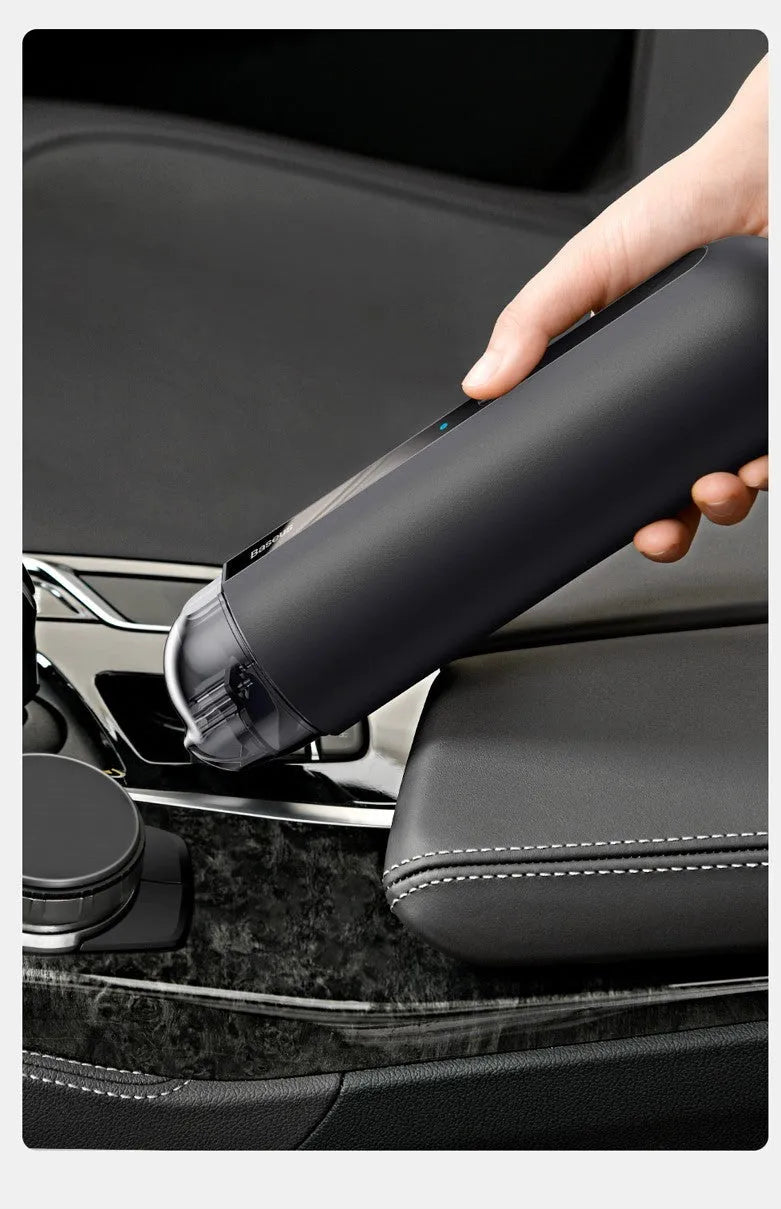BASEUS black handheld car vacuum cleaner with hose on a car seat.