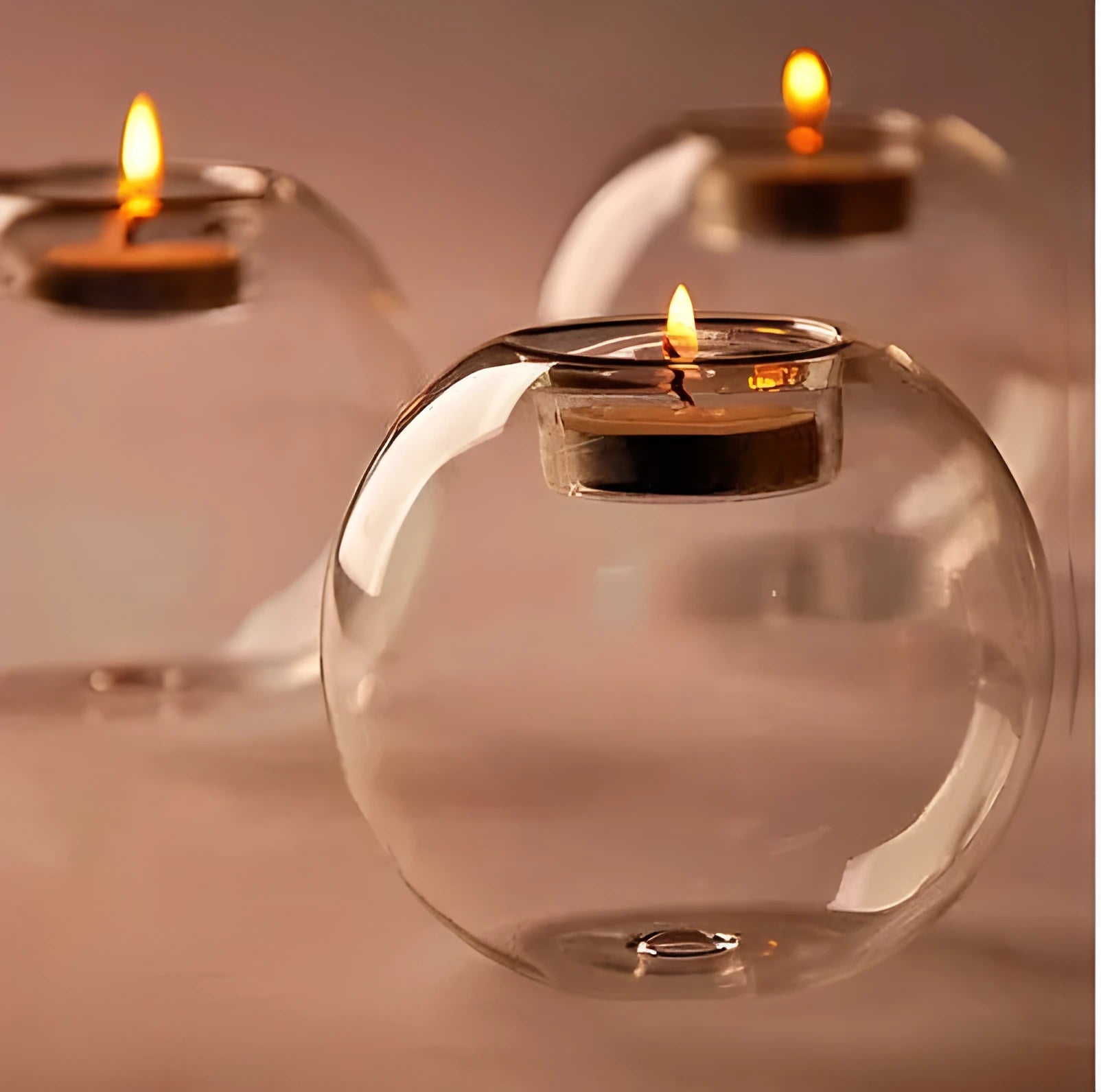 Handmade clear round hollow glass candle holder in three size options on wooden table