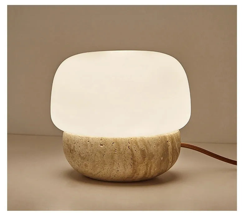 Cream-coloured retro style bedside table lamp with a warm white glow.