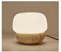 Cream-coloured retro style bedside table lamp with a warm white glow.