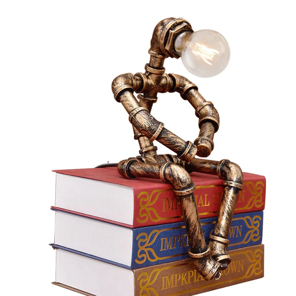 Green bronze vintage industrial robot desk lamp with iron pipe design on a wooden table.