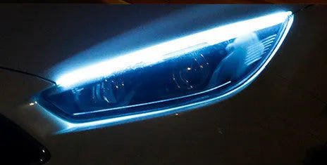 Universal car LED daytime running light strip with flowing turn signal on a vehicle headlight.