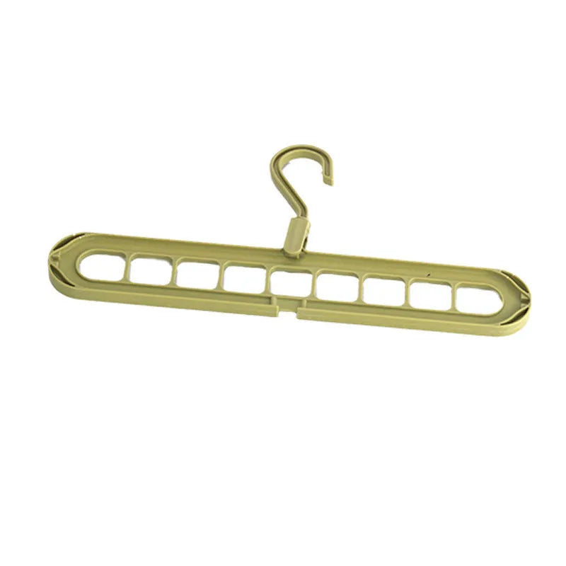 Green plastic multifunctional hanger with nine arms for folding trousers, shown hanging on a rail.