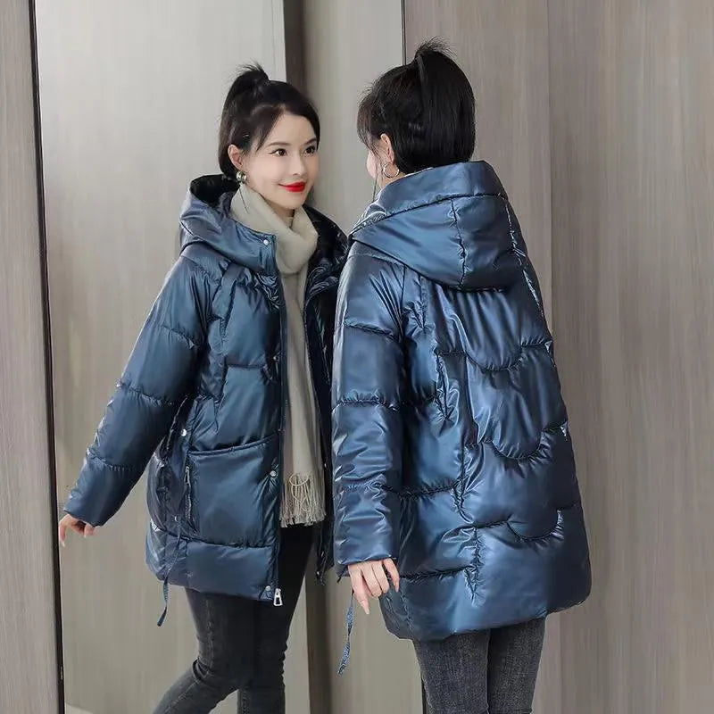 A woman wears a loose-fitting green hooded winter jacket with long sleeves.