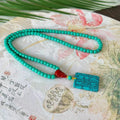 Hand-woven turquoise mesh flower lucky pendant on a ball bead necklace chain, adjustable length.