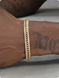 Gold-coloured tennis bracelet with gemstone detail on a titanium steel band.