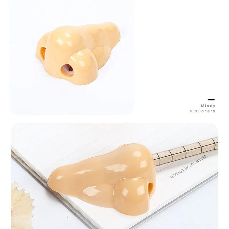 Flesh coloured plastic pencil sharpener with big nostril hole showing compact geometry shape