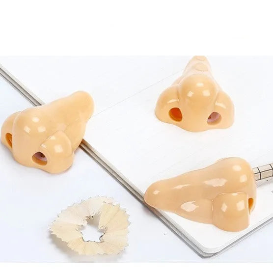Flesh coloured plastic pencil sharpener with big nostril hole showing compact geometry shape