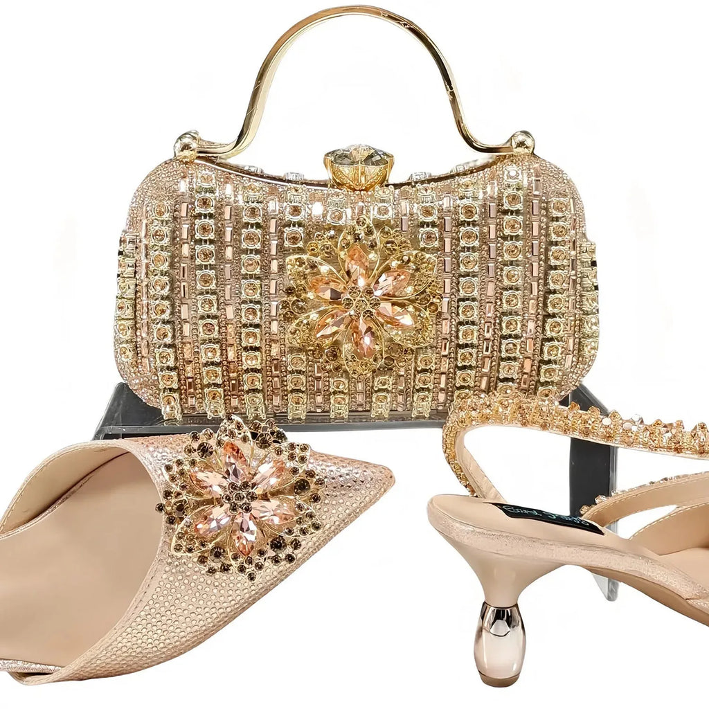 Women's black high heel sandals with ankle chain, floral rhinestone detail, and matching hard clutch bag