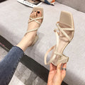 Women's white thick-heeled slip-on sandals with a high middle heel and open back.