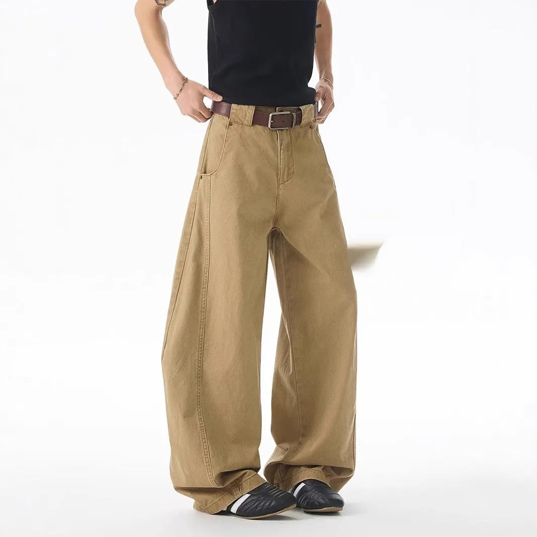 Brown men's loose-fit straight-leg jeans with a button fly on a mannequin.