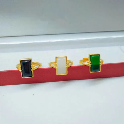 Adjustable brass gold-plated ring with a centre gemstone, shown in black, green, and white colour options.