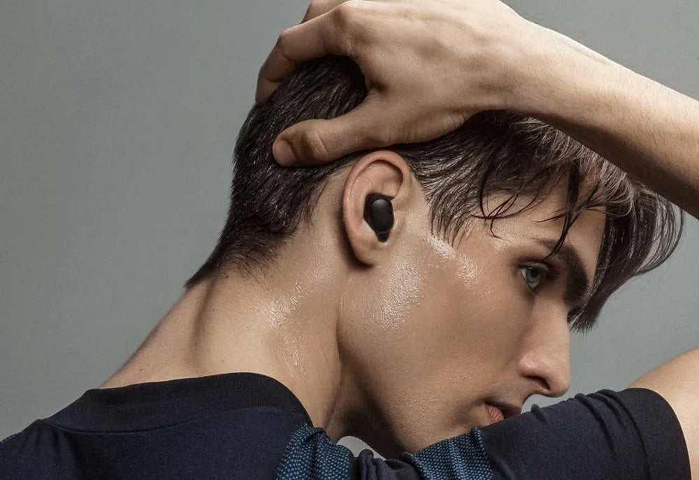 Redmi AirDots Black true wireless earbuds and their white charging case on a table