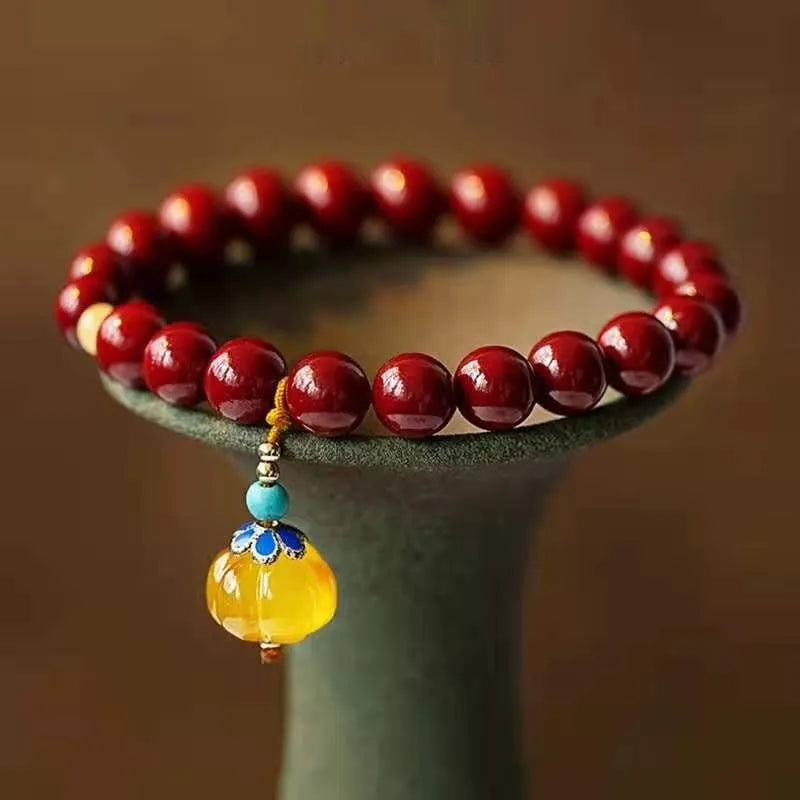Gold cinnabar and copper bead bracelet in a wave shape on a wrist.