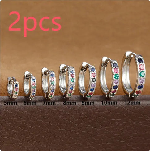Gold, rose gold, and silver coloured circle-shaped zircon stud earrings on a white background.