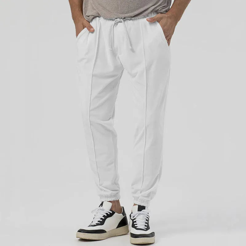 Men's grey casual tapered sweatpants with an elasticated waistband laid flat.