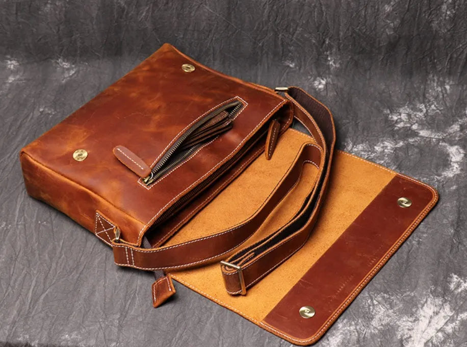 Brown vintage leather men's messenger bag with a flap opening and an adjustable shoulder strap.