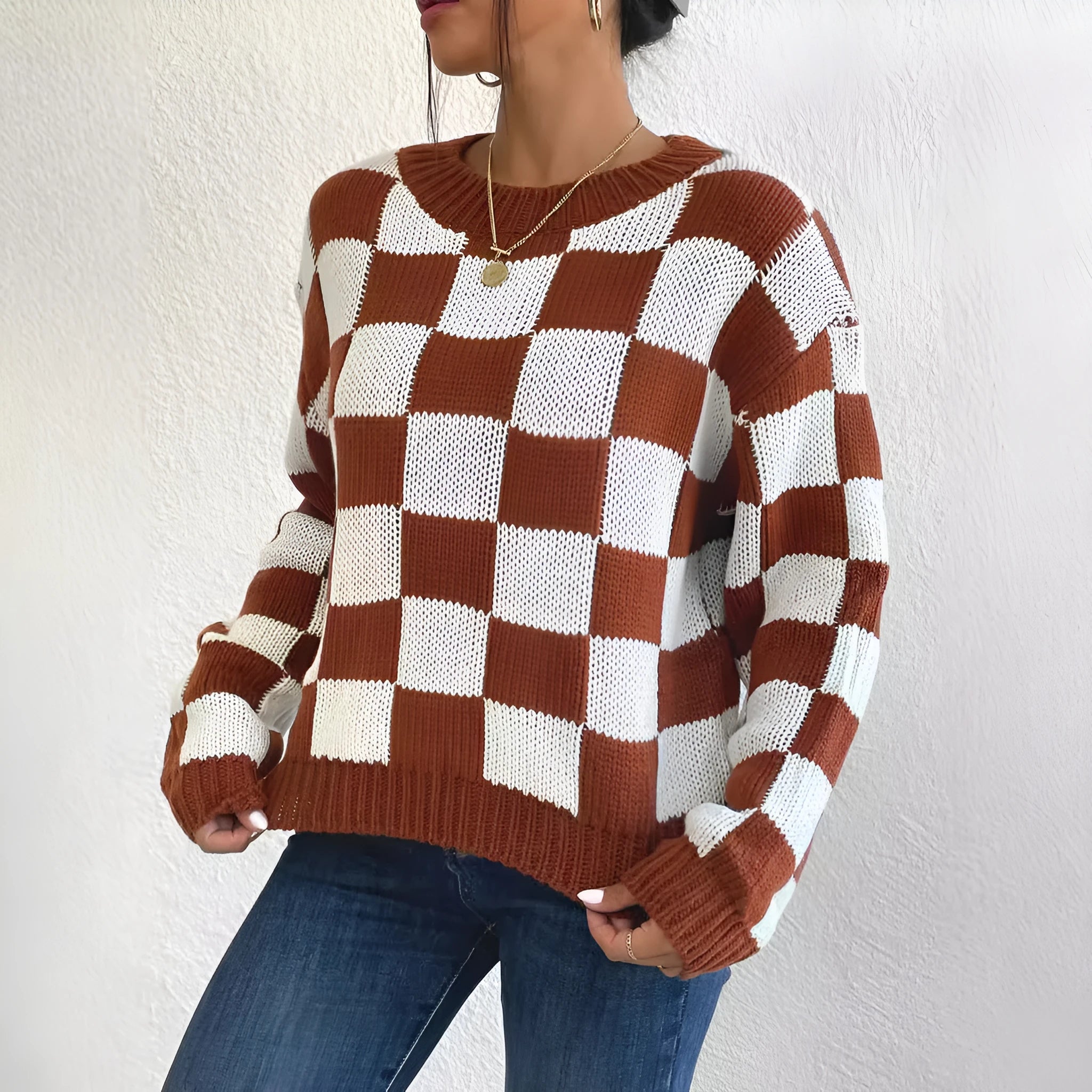 Dark brown plaid loose round neck acrylic pullover sweater on a hanger
