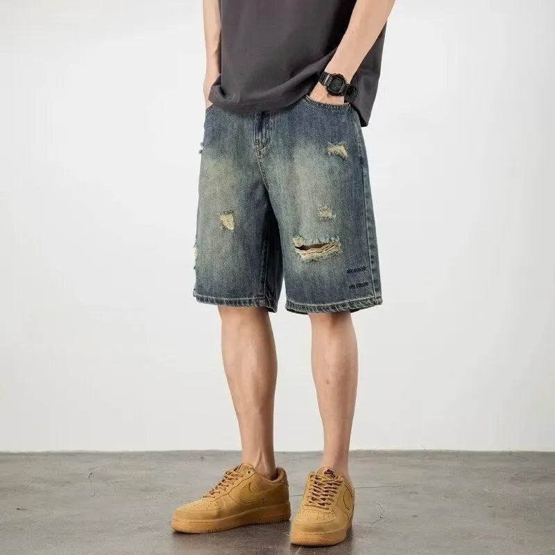 Men's blue distressed denim shorts with a straight leg and retro hole detailing.