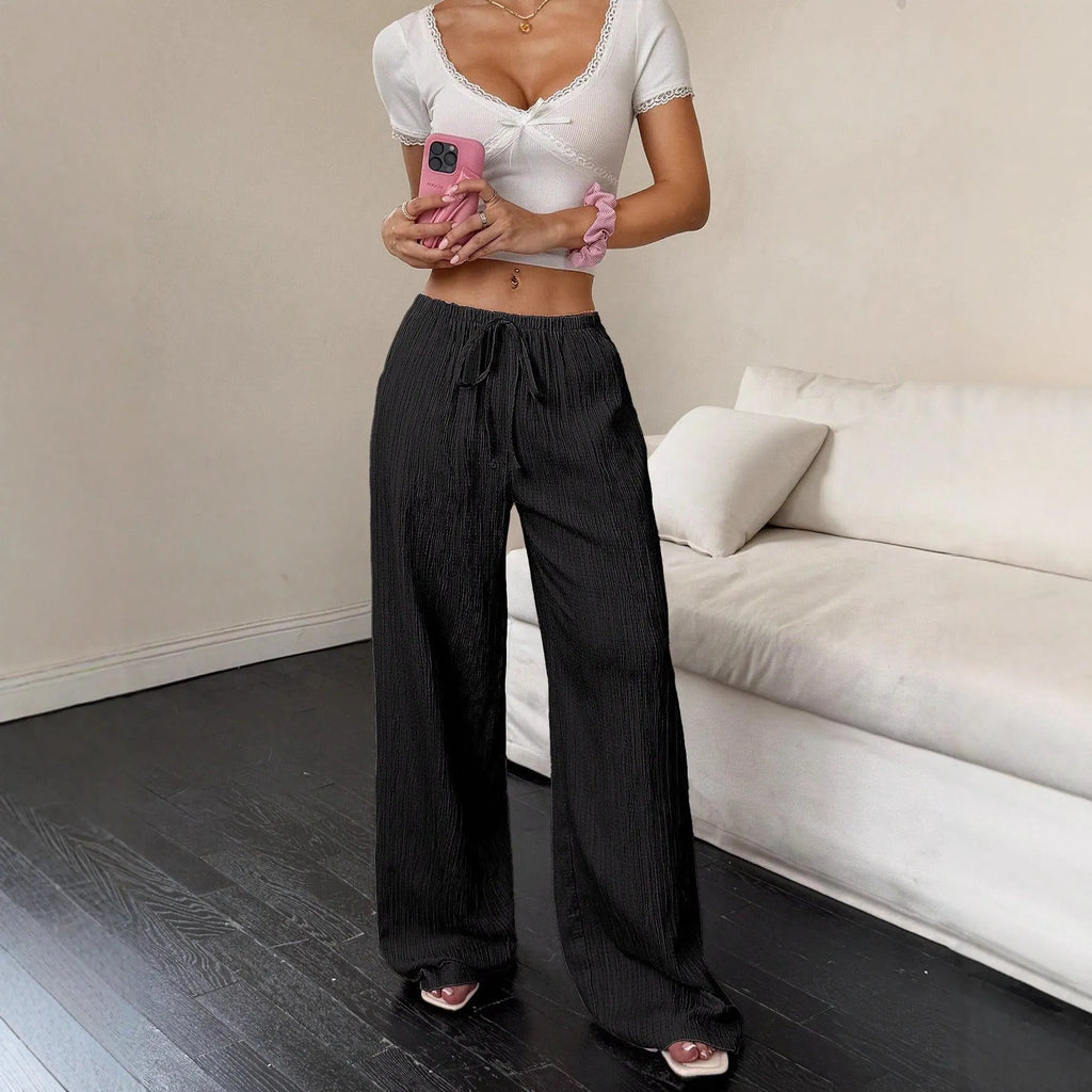 Women's black wide-leg trousers with lace-up waist trimming detail on hanger