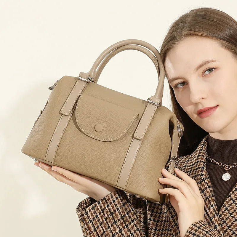 Genuine leather ladies handbag in black, brown, or elephant grey with contrast stitching and a lock.