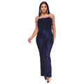 Woman wearing a black sleeveless backless jumpsuit with sequined top and flared legs.