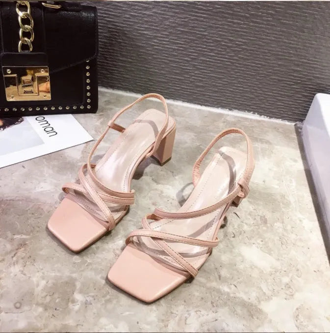 Women's white thick-heeled slip-on sandals with a high middle heel and open back.