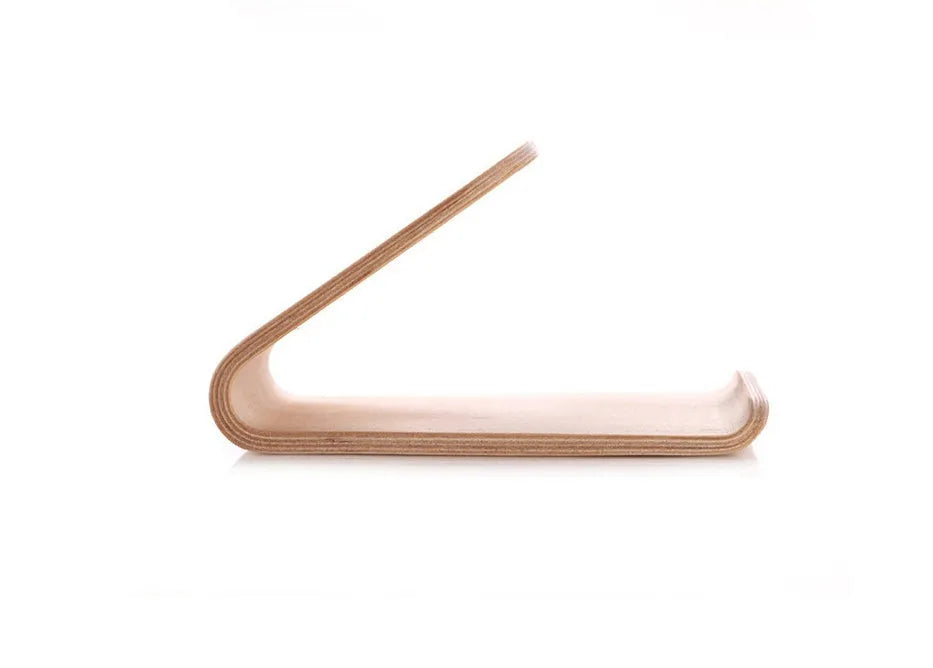 Handmade solid wood iPhone stand in walnut finish on a desk, holding a phone with a charging cable routed through the cable channel.
