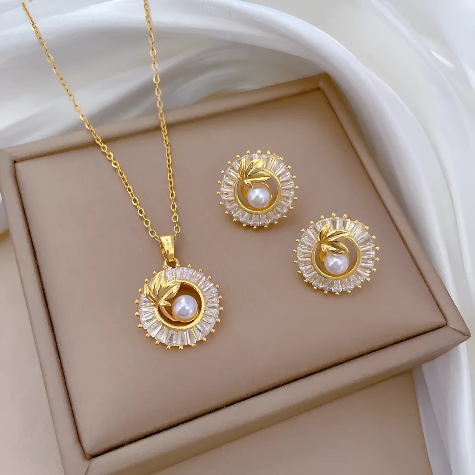 A titanium steel jewellery set with a square diamond and leaf design necklace and matching stud earrings.