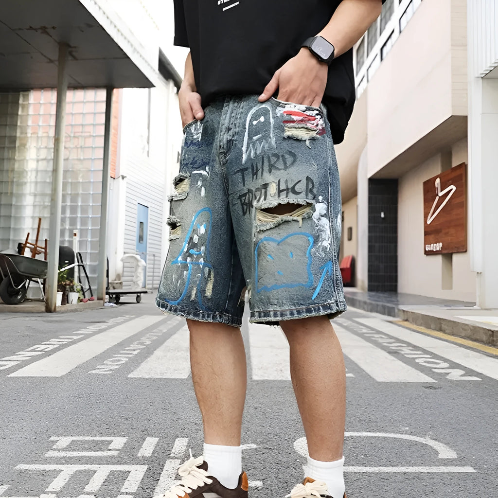 Blue ripped men's denim shorts with graffiti print and a zipper fly