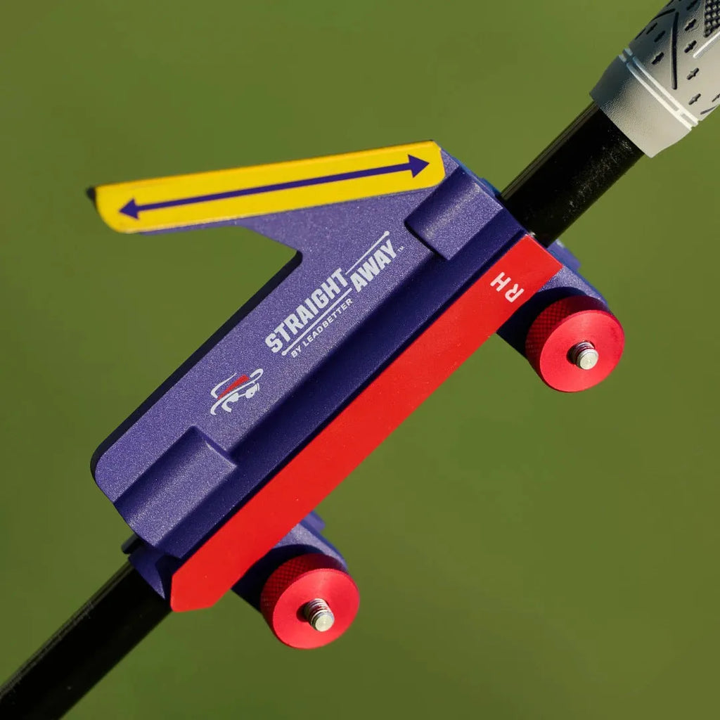 A plastic golf swing plane simulator training aid on a green background.