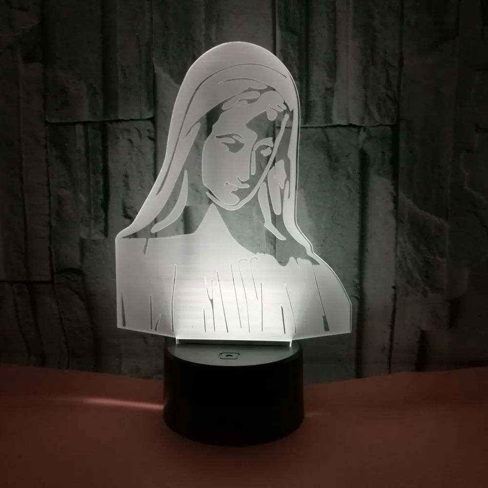 3D LED night light with colourful dual-ring pattern, remote control, and USB cable on a desk.