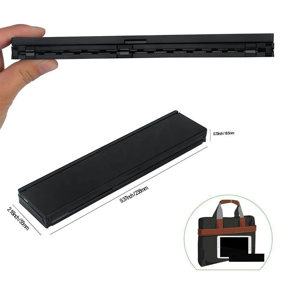 Black folding wireless Bluetooth keyboard unfolded next to tablet showing mini keyboard size