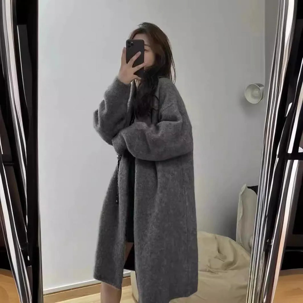 Women's knitted V-neck cardigan in loose fit showing mid-length silhouette and long sleeves