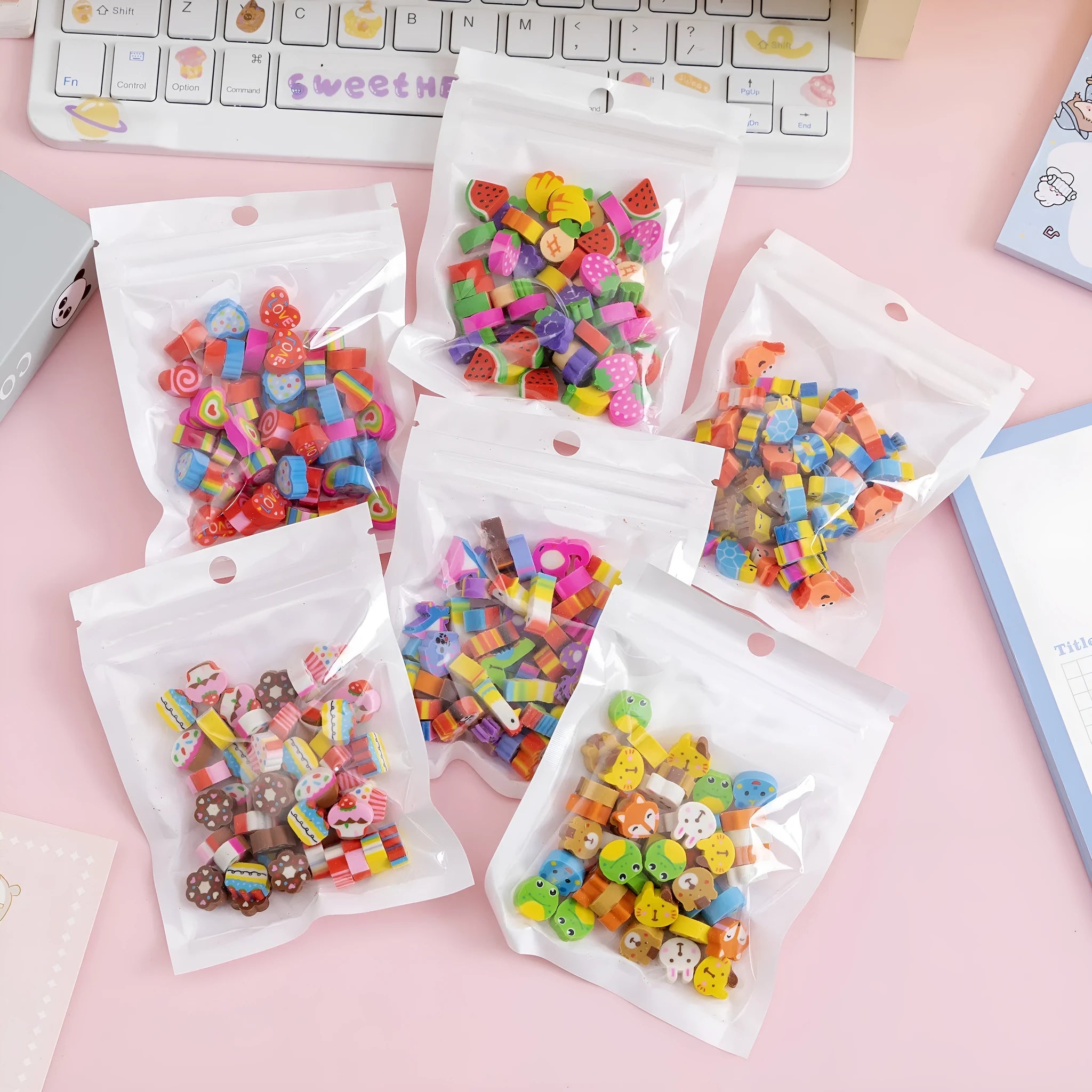 50 colourful cartoon mini erasers in pearlescent bags showing fruit, animal, and holiday designs
