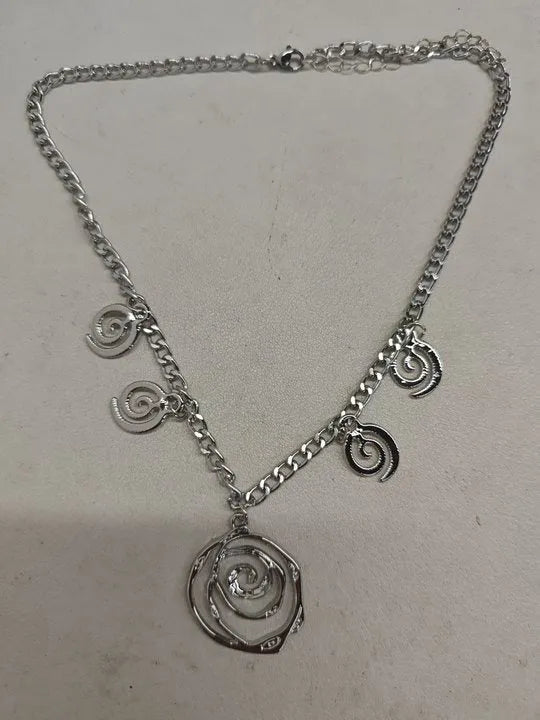 Women's spiral donut jewellery set showing bracelet, earrings, and adjustable necklace in gold tone