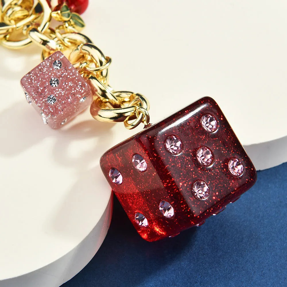 Vintage cherry two-tone dice design on a square electroplated metal keychain pendant.