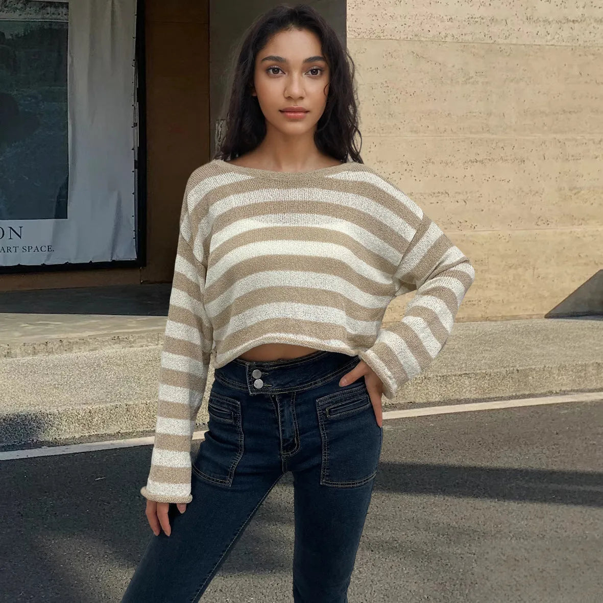 A striped long-sleeved pullover sweater with a cropped front and back design, shown in a selected colour.