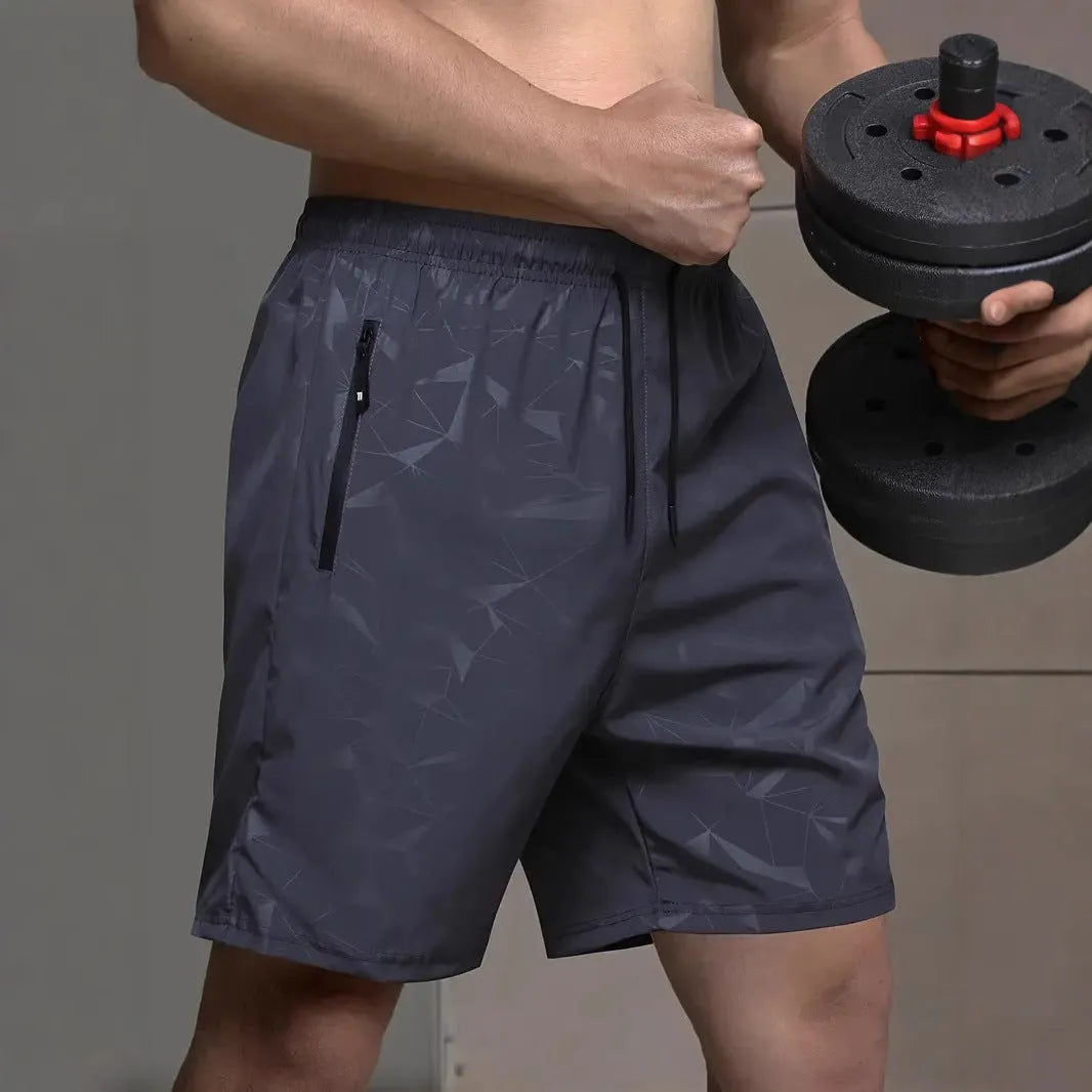 Man wearing loose grey polyester sports shorts with an elastic waistband.