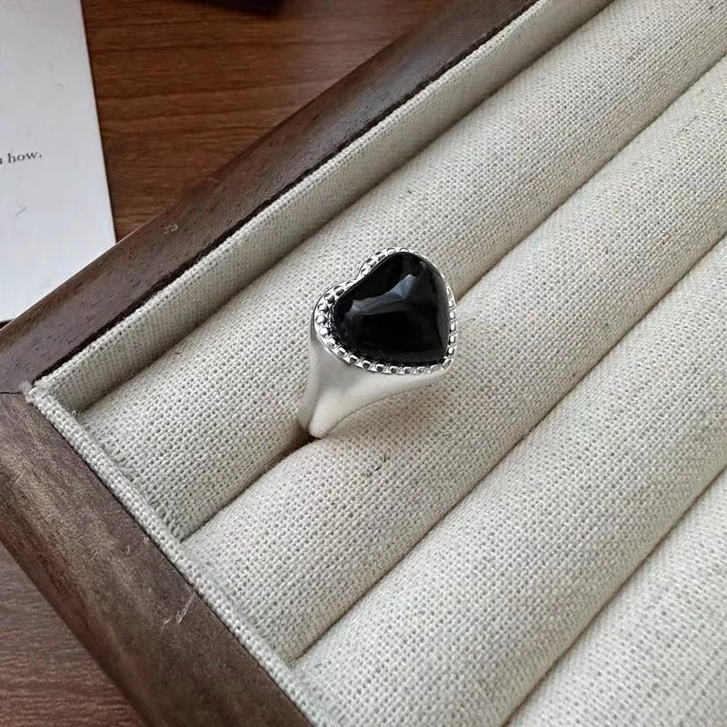 Adjustable open mouth sterling silver ring with a black agate heart on a silver band.