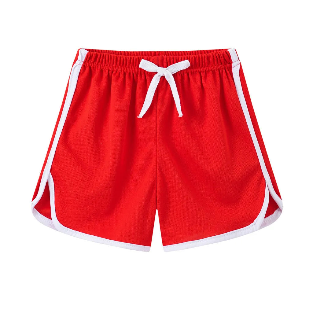 Children's patterned beach shorts in various colours including leopard print, floral, and fruit designs
